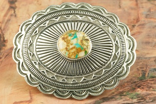 Genuine Boulder Turquoise set in Sterling Silver Belt Buckle. Created by Navajo Artist Tsosie White. The cabochon is Boulder Turquoise, you can see the veins of Turquoise running through the host rock. The Boulder Turquoise Mine is located in northeast Nevada. It was discovered in 1970 by a Shoshone sheep herder. Production is small due to the remote location and winter weather. Boulder Turquoise is valued for both it's beauty and rarity. Every stone is unique. 
